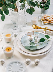 Image showing Christmas table setting with eucalyptus, cutlery and candles in white and green tone