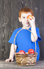 Image showing red-haired boy playing with mature nectarines