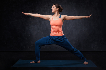 Image showing Woman practices yoga asana utthita Virabhadrasana