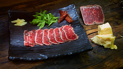 Image showing Barbecue wagyu roast beef sliced as top view on a metal tray with copy space right