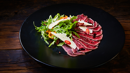 Image showing Barbecue wagyu roast beef sliced as top view on a metal tray with copy space right