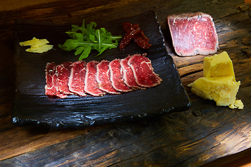 Image showing Barbecue wagyu roast beef sliced as top view on a metal tray with copy space right