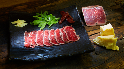 Image showing Barbecue wagyu roast beef sliced as top view on a metal tray with copy space right