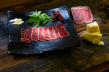 Image showing Barbecue wagyu roast beef sliced as top view on a metal tray with copy space right