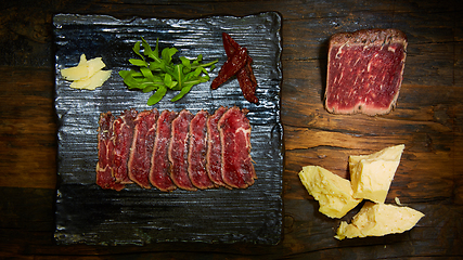 Image showing Barbecue wagyu roast beef sliced as top view on a metal tray with copy space right