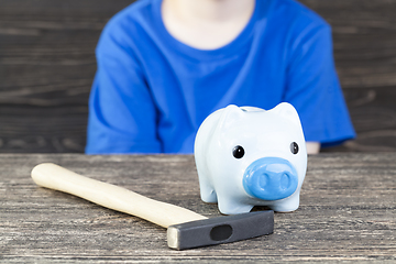 Image showing boy wants to break his piggy bank