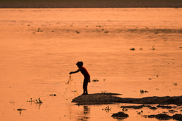 Image showing Asian Woman fishing in the river, silhouette at sunset