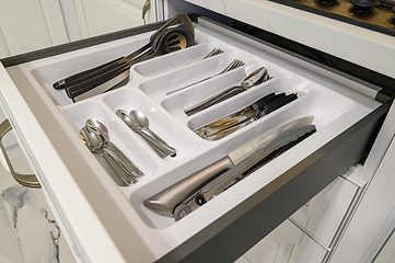 Image showing Open drawer with cutlery at modern white woden kitchen in classic style