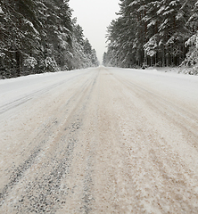 Image showing a dirty, broken snow-covered road