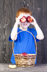 Image showing red-haired boy playing with mature nectarines