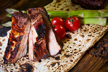 Image showing Roasted sliced barbecue pork ribs, focus on sliced meat