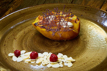 Image showing Grilled pear dessert decorated with chocolate and almonds