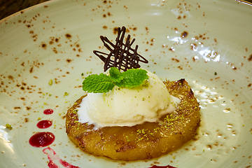 Image showing Grilled pineapple with scoops of vanilla ice cream.