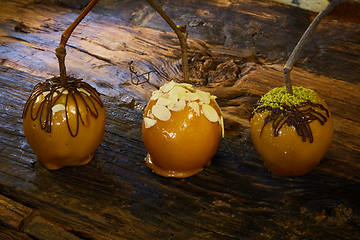 Image showing Homemade Caramel Apples on a Stick for Halloween. Organic Snack - Caramel Apples with Walnuts.