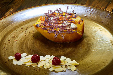 Image showing Grilled pear dessert decorated with chocolate and almonds