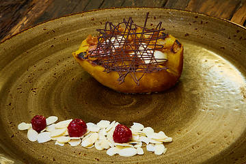 Image showing Grilled pear dessert decorated with chocolate and almonds