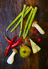 Image showing Assorted vegetables. Pepper, mushrooms, quince, cherry tomatoes and asparagus on a wooden board