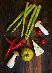 Image showing Assorted vegetables. Pepper, mushrooms, quince, cherry tomatoes and asparagus on a wooden board