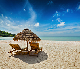 Image showing Two beach lounge chairs under tent