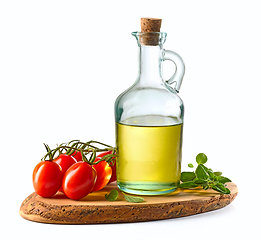 Image showing olive oil and tomatoes on wooden cutting board