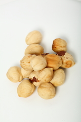 Image showing The handful of organic shelled hazelnuts on white background. Shallow dof.