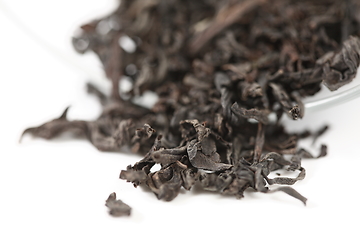 Image showing dry black tea leaves on white background. Shallow dof.