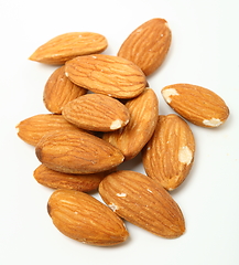 Image showing Heap of organic almond nuts on white background. Shallow dof.