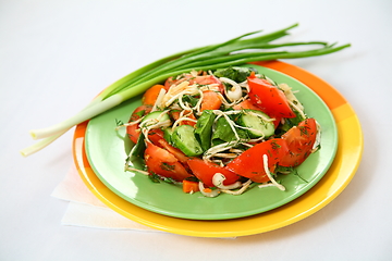 Image showing The salad with cucumbers, tomatoes and herbs