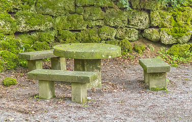 Image showing overgrown stone benches and table