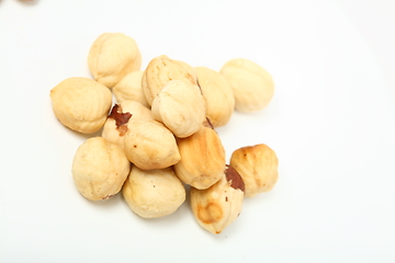 Image showing The handful of organic shelled hazelnuts on white background. Shallow dof.