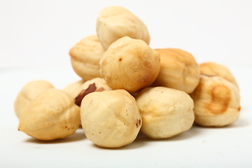 Image showing The handful of organic shelled hazelnuts on white background. Shallow dof.