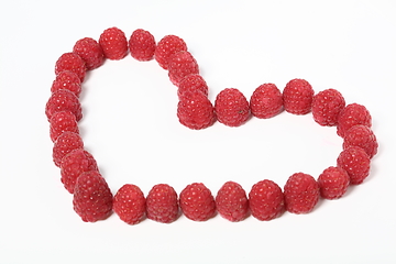 Image showing Heart made out of raspberries over white background