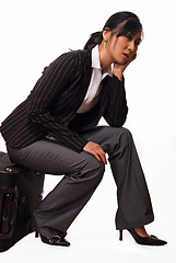 Image showing Woman sitting on luggage