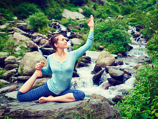 Image showing Sorty fit woman doing yoga asana outdoors at tropical waterfall