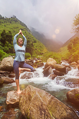 Image showing Woman in yoga asana Vrikshasana tree pose at waterfall outdoors