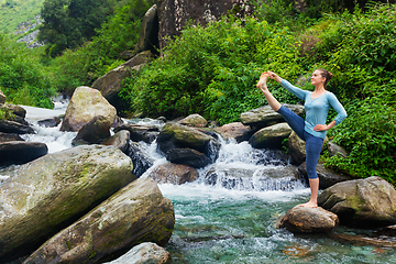 Image showing Woman doing Ashtanga Vinyasa Yoga asana outdoors at waterfall