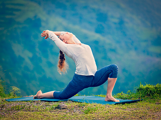 Image showing Sporty fit woman practices yoga asana Anjaneyasana in mountains