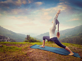 Image showing Woman doing yoga asana Virabhadrasana 1 - Warrior pose outdoors