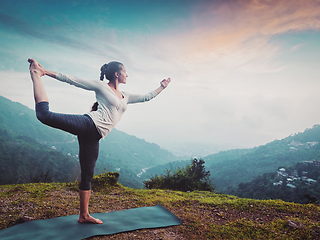 Image showing Woman doing yoga asana Natarajasana outdoors at waterfall