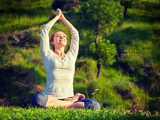 Image showing Young sporty fit woman doing yoga Lotus pose oudoors