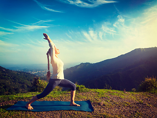 Image showing Woman doing yoga asana Virabhadrasana 1 - Warrior pose outdoors