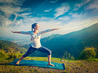 Image showing Woman doing yoga asana Virabhadrasana 2 - Warrior pose outdoors