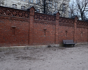 Image showing old high brick fence and a bench 