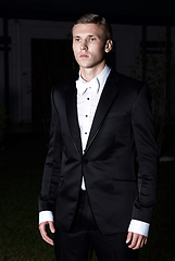 Image showing Portrait of an attractive young businessman in urban background wearing suit and necktie. Looking to the camera. Classic style. Studio shot