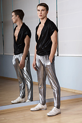 Image showing Man in elegant sport suit posing in fitness gym. Young man in silver sport leggings