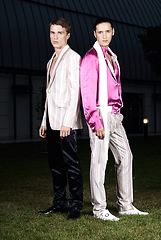 Image showing Fashion portrait of two young sexy handsome men models in casual cloth suit on green grass