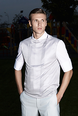 Image showing Portrait of an attractive young businessman in urban background wearing suit and necktie. Looking to the camera. Classic style. Studio shot