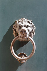 Image showing Doorknocker with head of lion on a green wooden door