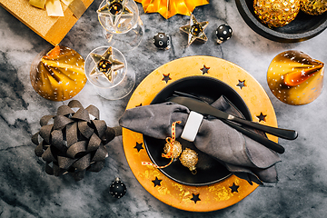 Image showing Glamorous black and gold place setting with modern plates for New Years Eve and Christmas