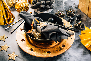 Image showing Glamorous black and gold place setting with modern plates for New Years Eve and Christmas